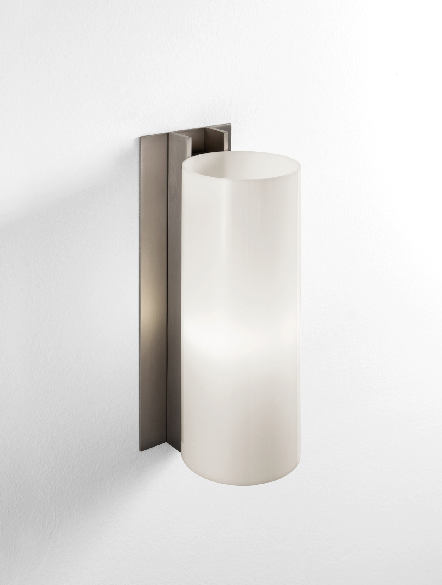 TMM Metálico Wandleuchte von Santa & Cole mit zylindrischem Lampenschirm und Metallhalterung an weißer Wand.