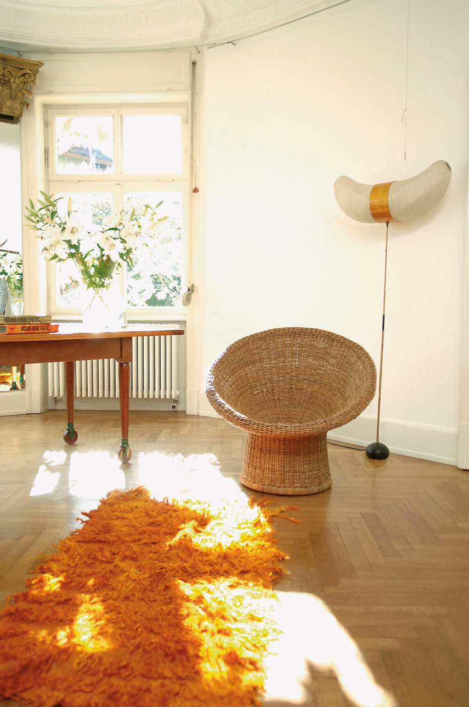 E 10 Rattansessel von Richard Lampert in hellem Raum mit Teppich und Tageslicht.