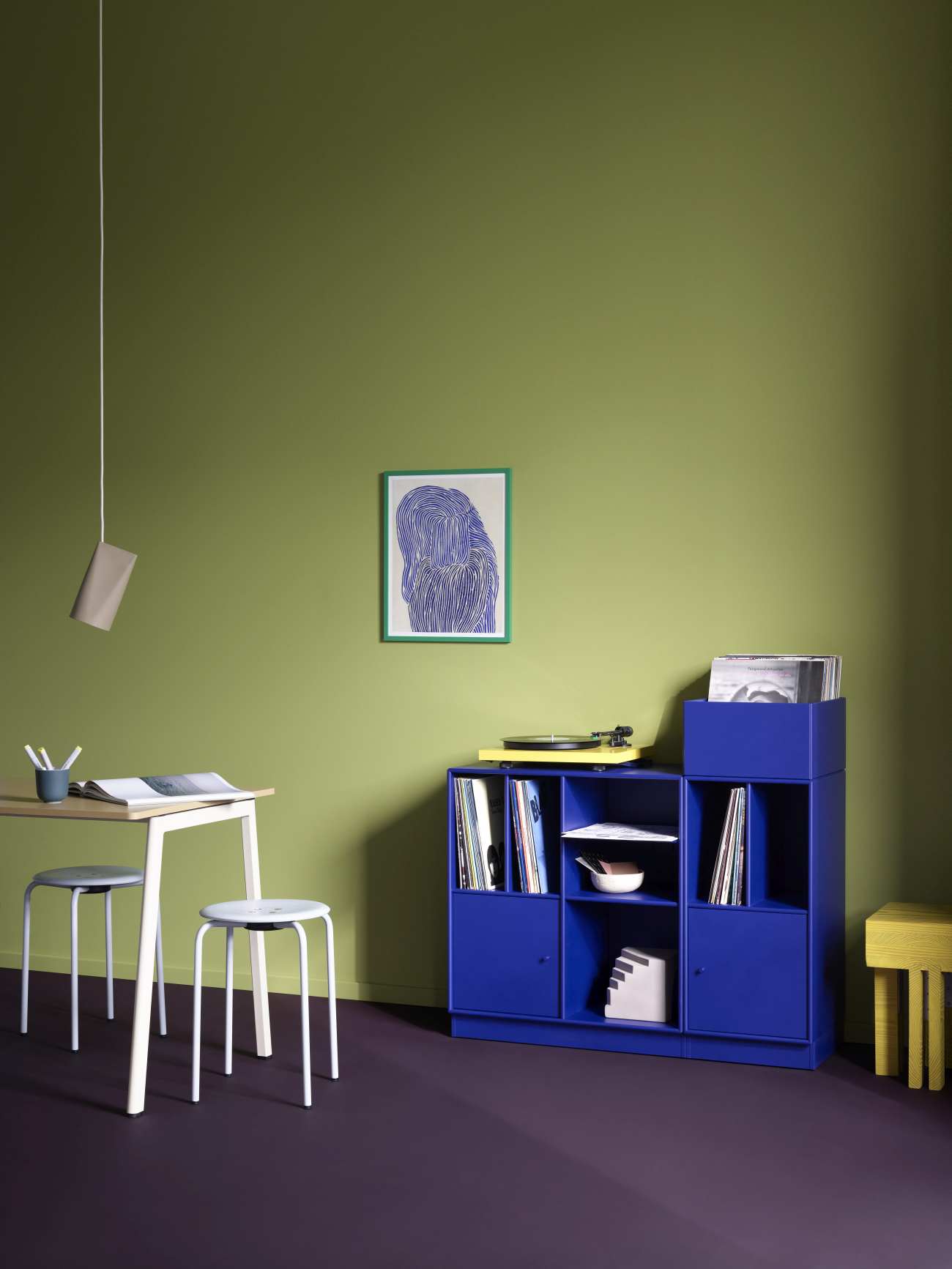 Blaues Montana Regal zur Schallplattenaufbewahrung mit Schallplattenspieler und Schallplatten in einem stilvollen Wohnzimmer.