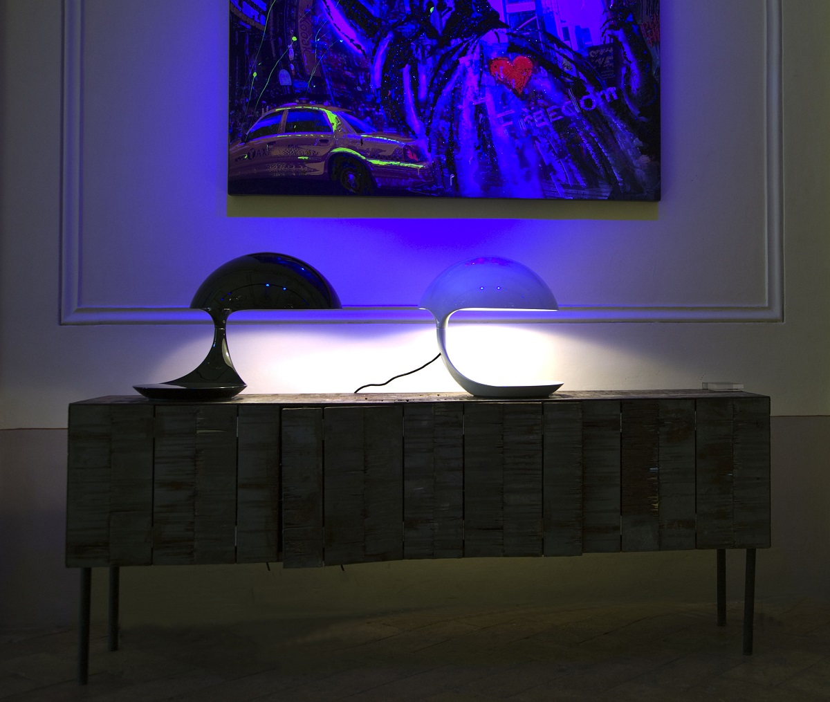 Zwei Cobra Tischleuchten von Martinelli Luce auf einem Holzschrank, modernes Design, stimmungsvolle Beleuchtung.