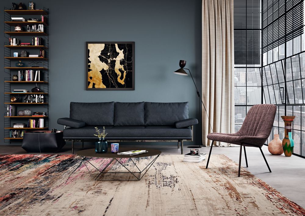 Wohnzimmer mit grauem Walter Knoll Sofa, Designermöbeln und modernem Teppich.
