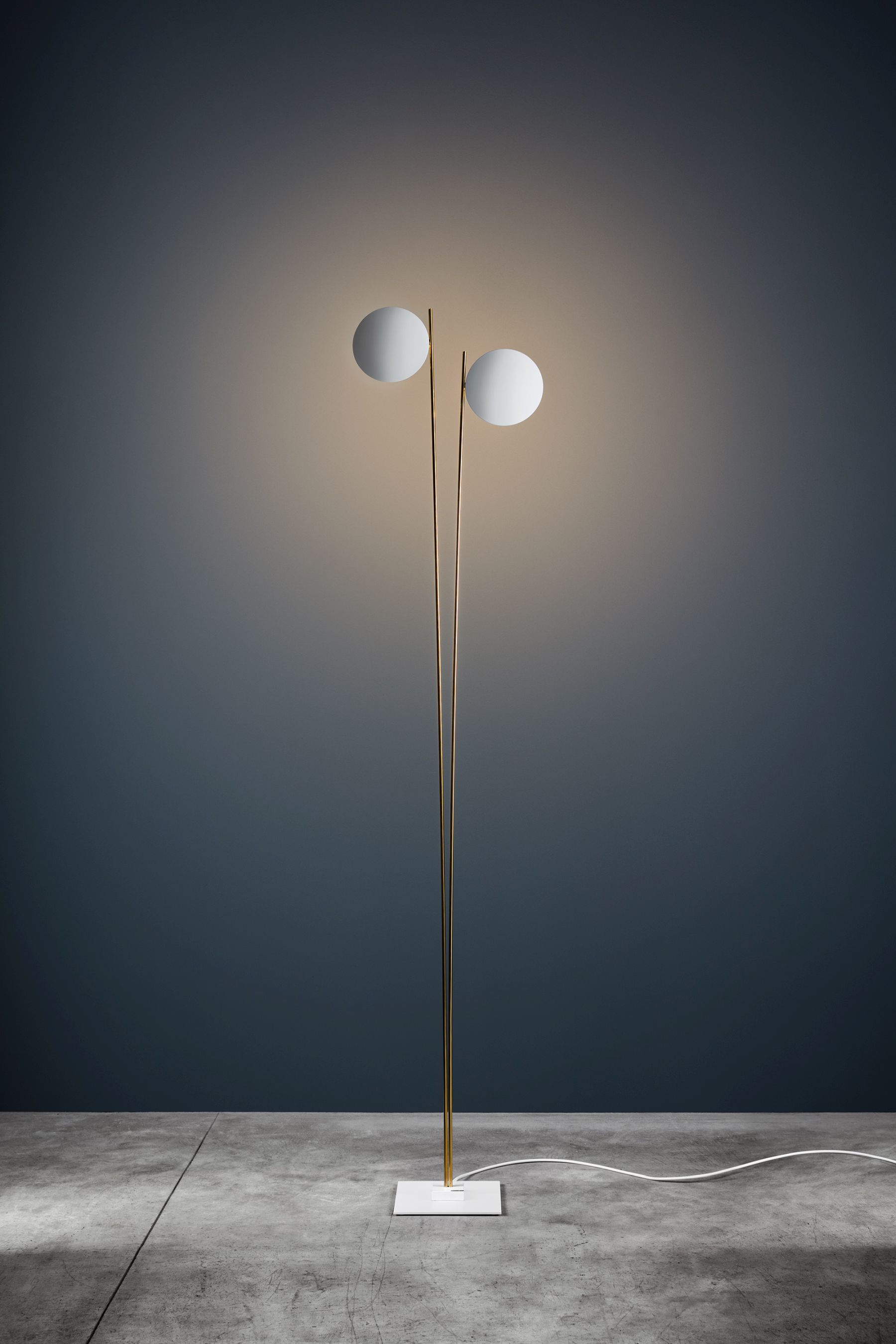 Lederam F2 Stehleuchte von Catellani & Smith mit zwei runden, leuchtenden Schirmen.