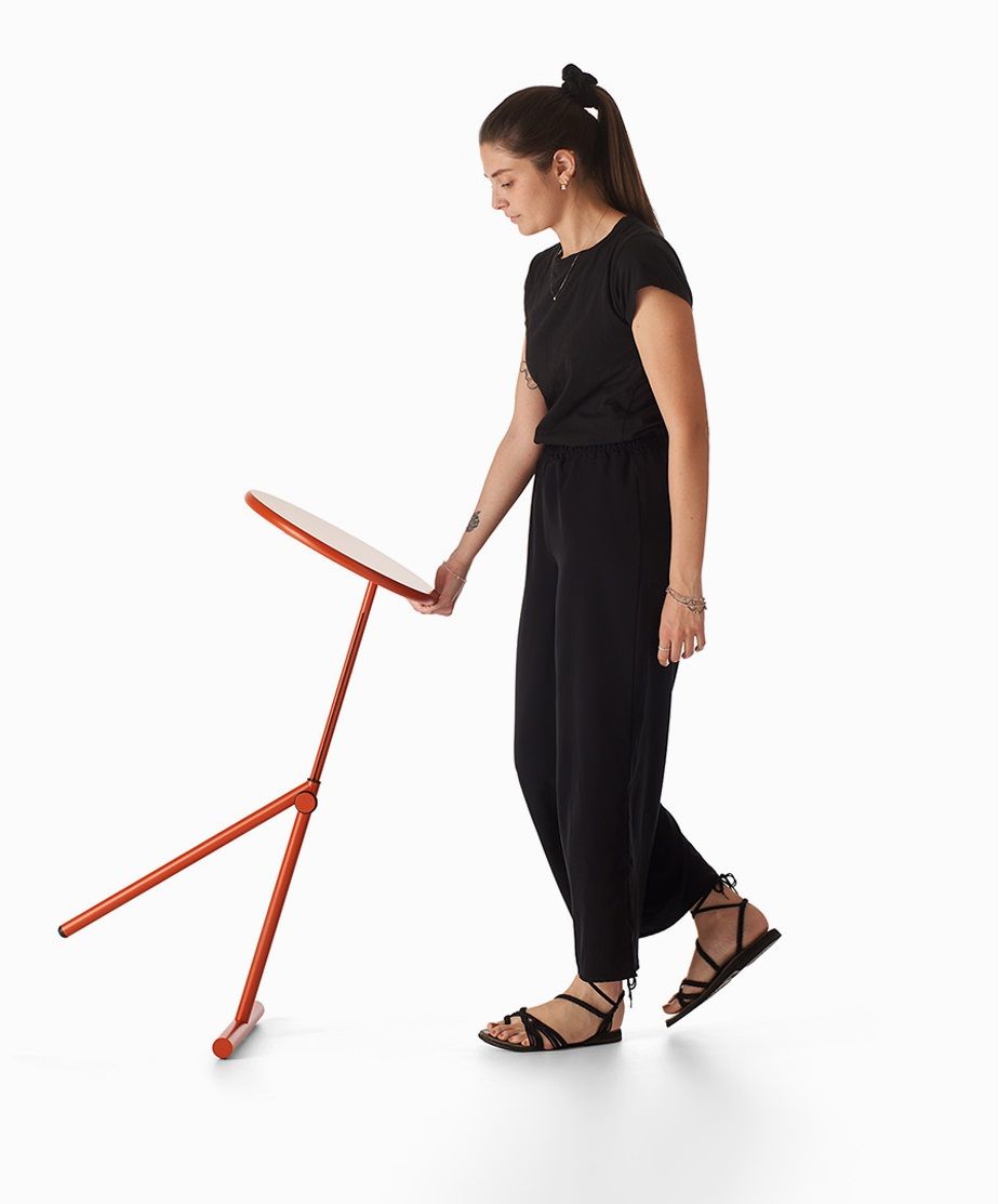 Frau bewegt Koji Beistelltisch von Opinion Ciatti, höhenverstellbarer, orangefarbener Couchtisch für Wohnzimmer.