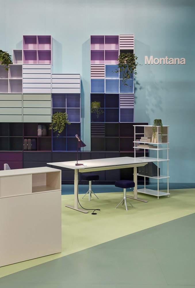 HiLow 2 Montana Arbeitstisch: Elektrisch höhenverstellbarer Schreibtisch in modernem Büro mit Regalsystem.