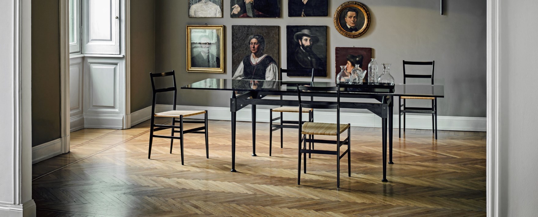 Superleggera Stuhl von Cassina, schwarzes Holzgestell und Sitzfläche aus Naturfaser, im Esszimmer.