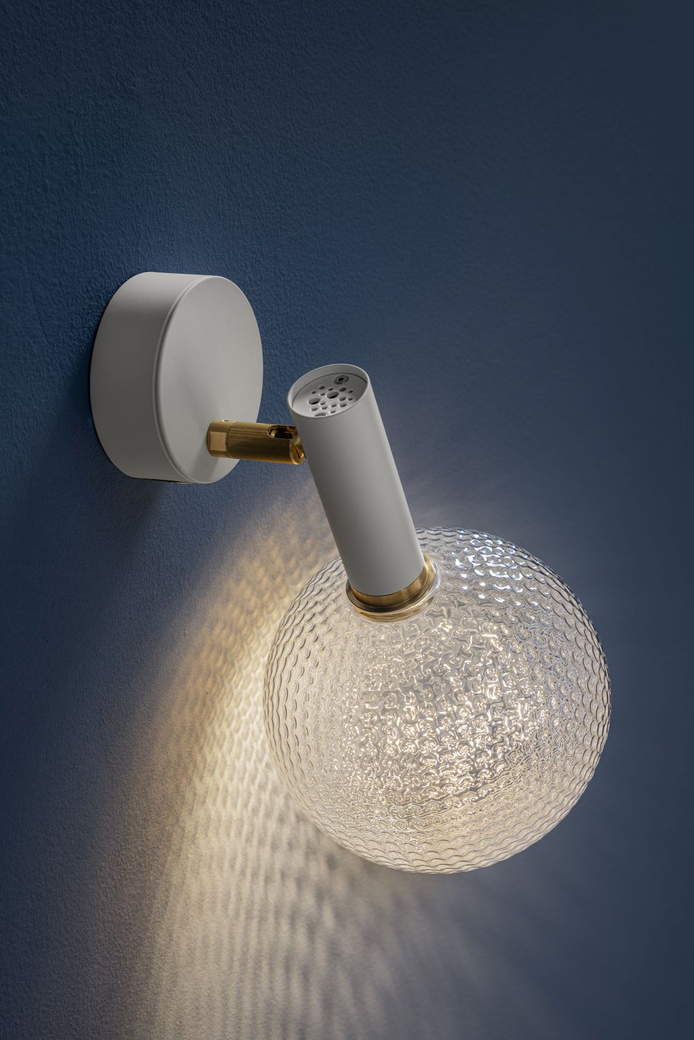 Nahaufnahme der Catellani & Smith Wandleuchte Par 18 mit strukturiertem Glas und warmem Licht.