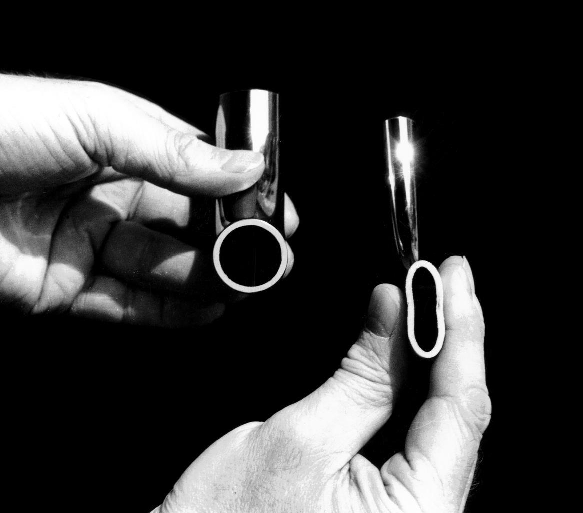 Zwei Kufengleiter für Kragstühle, Rundrohr-Gleiter, in Händen gehalten, Detailaufnahme.