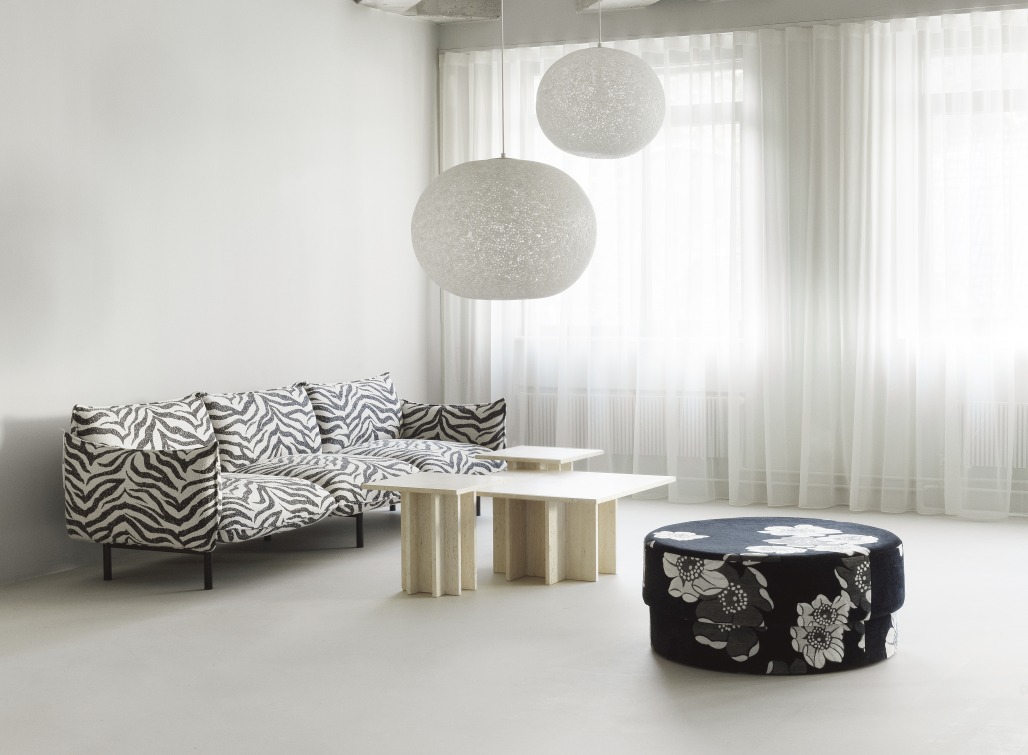 Zwei Act Lamp Pendelleuchten von Normann Copenhagen über Sofa und Couchtisch im Wohnzimmer.