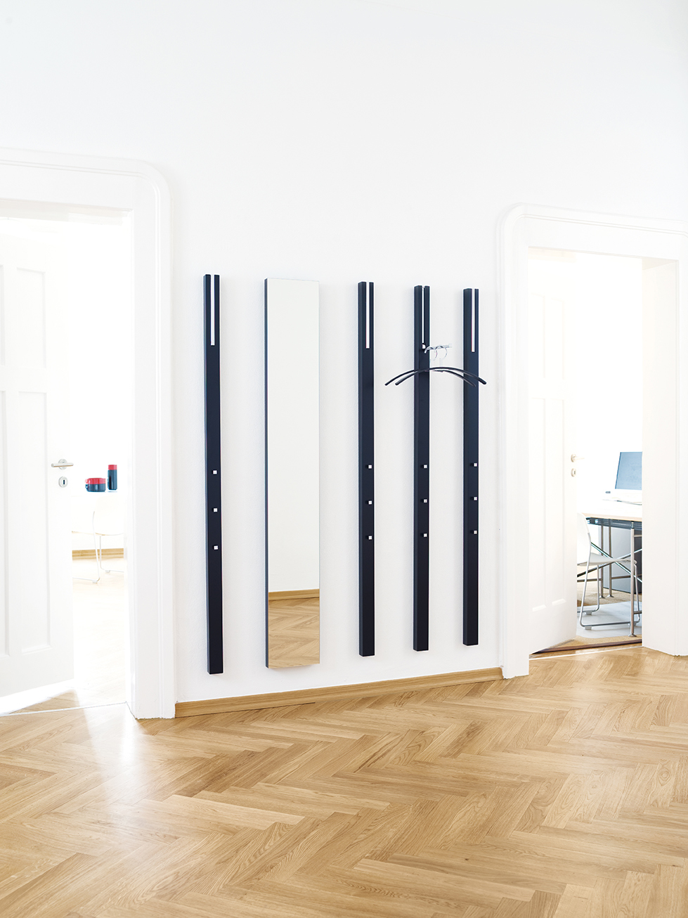 Schönbuch Line Spiegel und Garderobenelemente in Schwarz an weißer Wand über Parkettboden. Moderner Flurspiegel und Garderobe.