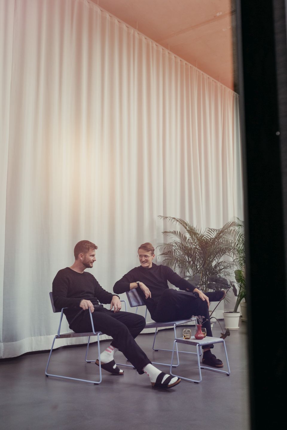 Zwei Männer sitzen auf Stühlen neben dem D:002 Beistelltisch Fuchs & Habicht.