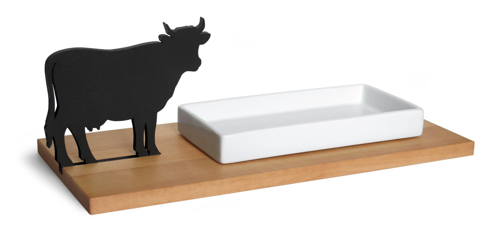 Käseschale mit Kuh-Motiv: Weiße Keramikschale neben schwarzer Kuh-Silhouette auf Holzbrett. Dekorative Käseplatte.