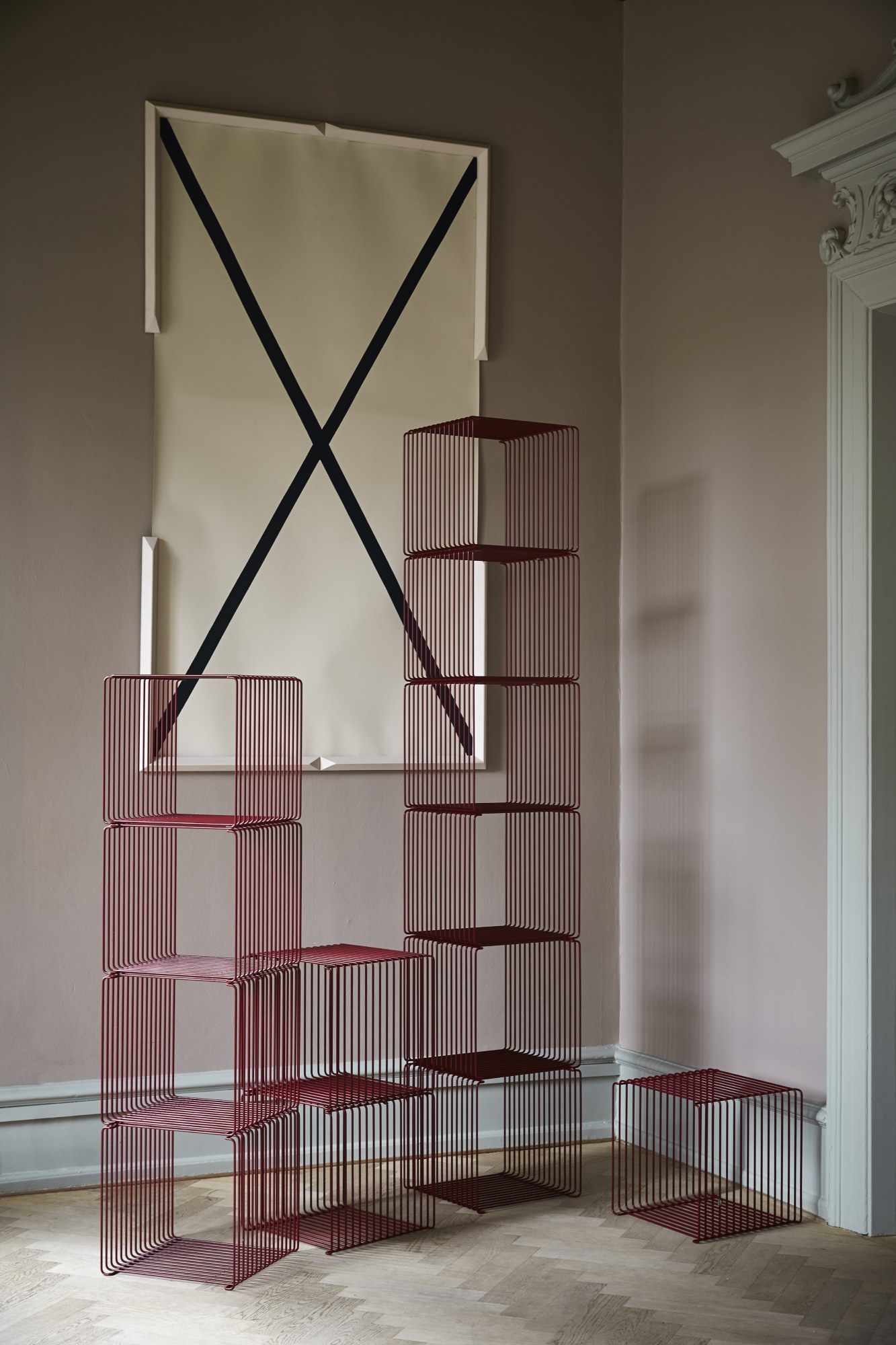 Burgunderrotes Montana Wire Cube Regal, bestehend aus mehreren Würfeln, gestapelt im modernen Wohnraum.