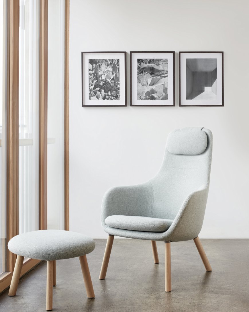 Heller Vitra Hal Lounge Chair Sessel mit Ottoman Sitzkissen und Holzbeinen vor Fenster.