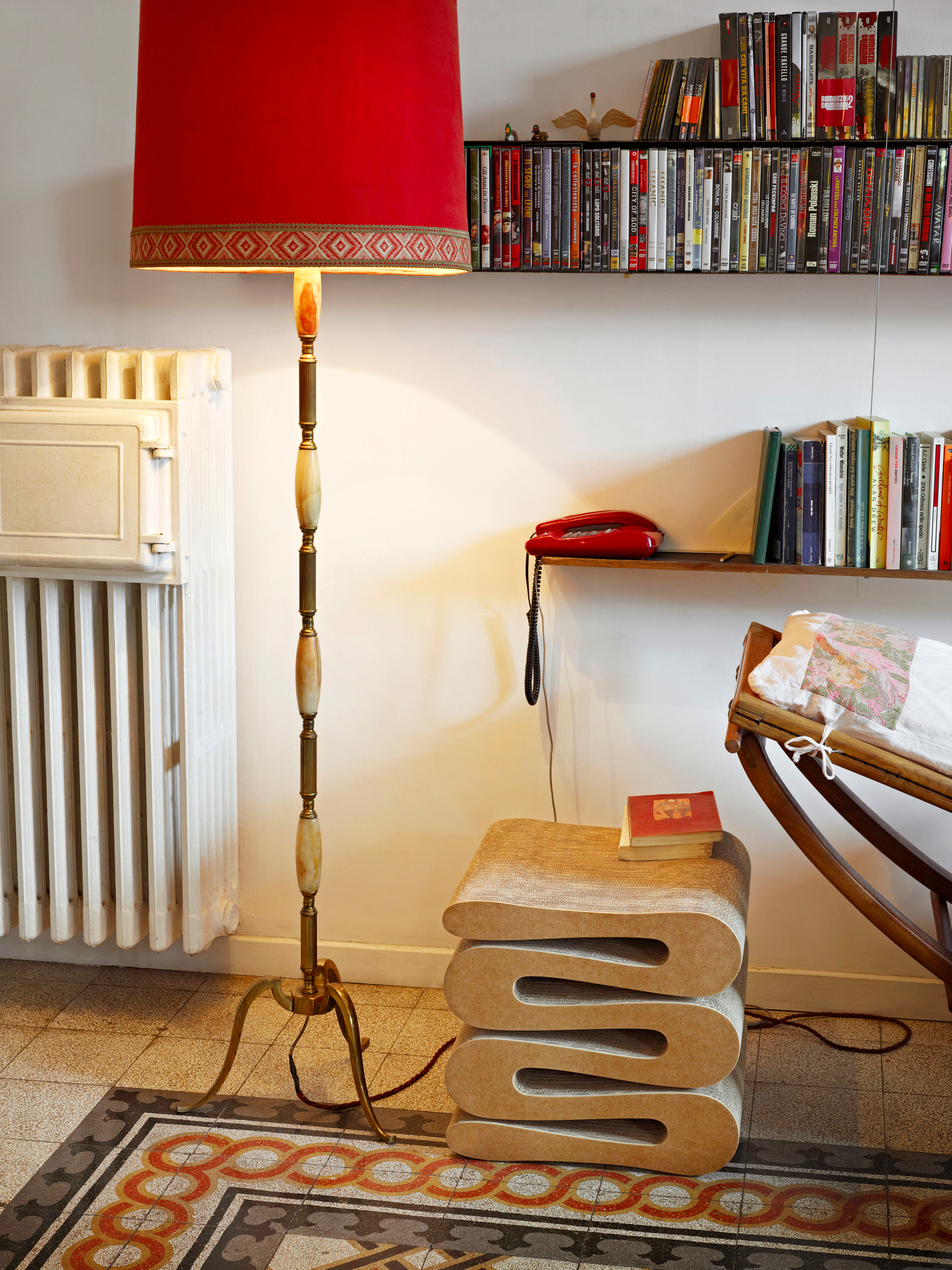 Vitra Wiggle Stool Hocker aus Wellpappe im Wohnzimmer mit Stehlampe und Bücherregal.