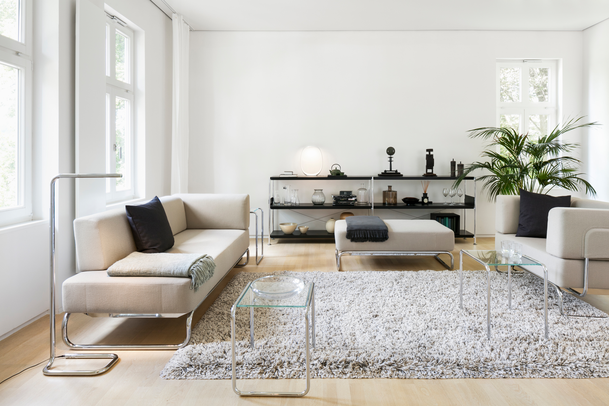 Heller Wohnraum mit Thonet Sessel, Sofa, Couchtisch und Regal im modernen Design.