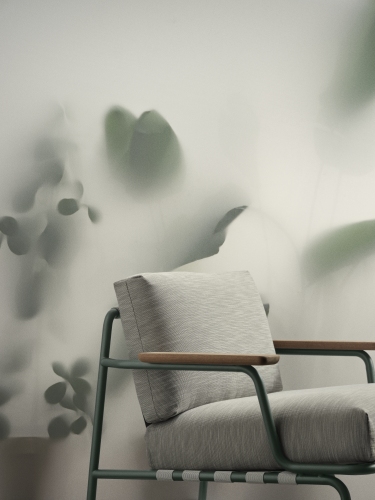 Nahaufnahme des Muuto Settle Lounge Chair Outdoor Sessels mit grauem Bezug und grünen Rahmen.