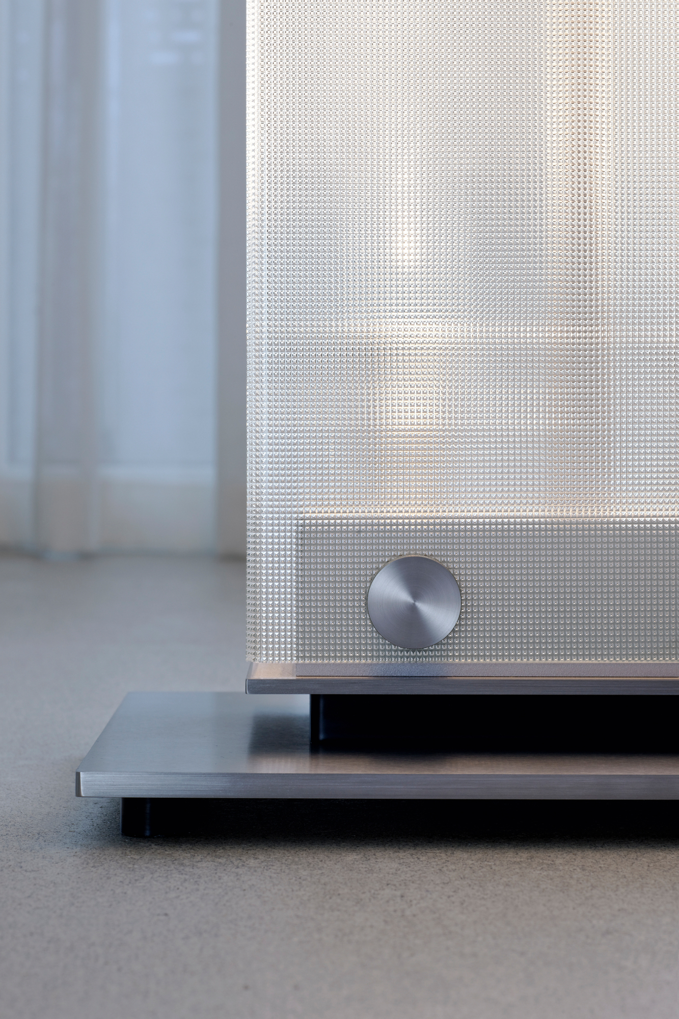 Detailaufnahme der Twilight LED Stehleuchte von Belux mit strukturiertem Glasdiffusor und silbernem Fuß.