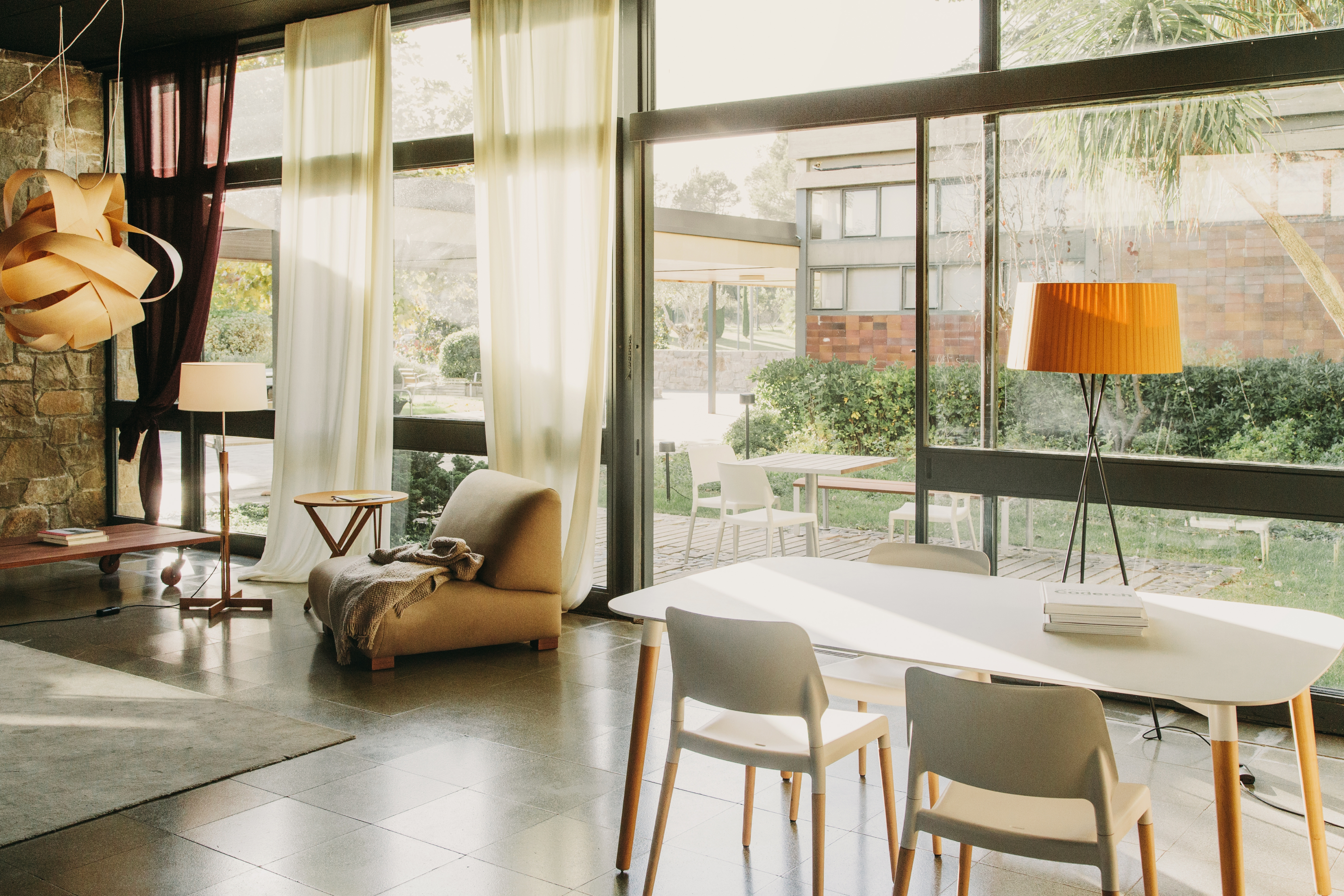 Heller Raum mit Belloch Esstisch von Santa & Cole, weißen Stühlen und großem Fenster.