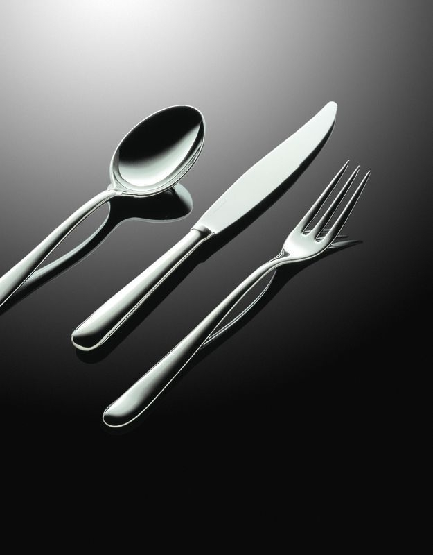 Nahaufnahme von Alessi Caccia Besteck: Messer, Gabel und Löffel aus poliertem Edelstahl. Hochwertiges Besteckset für stilvolles Essen.