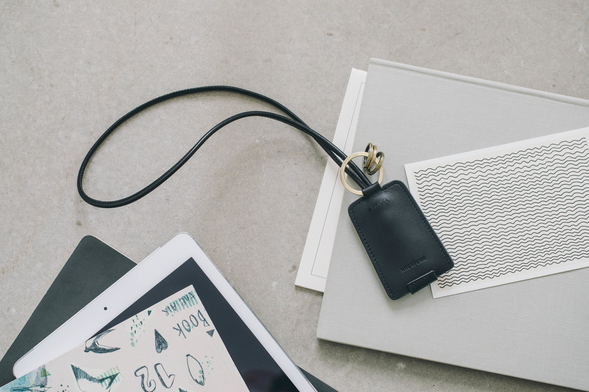 cCHAIN Schlüsselanhänger von Kreafunk mit USB-Kabel, schwarzes Leder, goldene Ringe, modernes Accessoire für unterwegs.