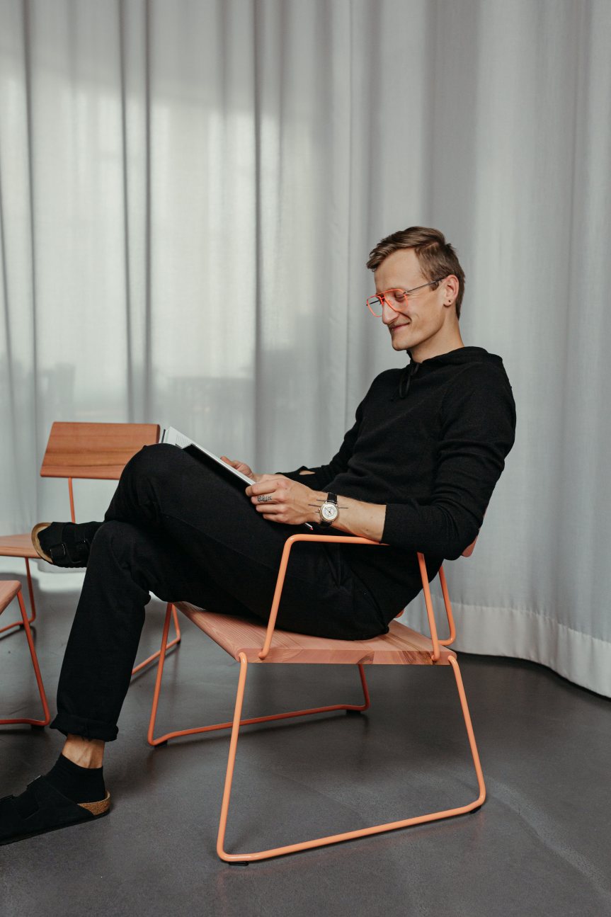Mann liest auf einem D:008 Loungechair von Fuchs & Habicht. Bequemer Sessel mit Armlehnen.