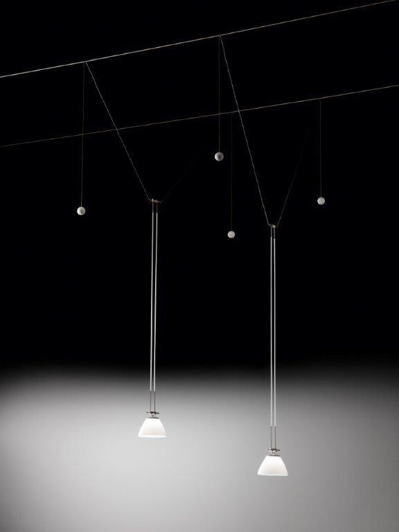 YAYAHO Lichtsystem von Ingo Maurer mit zwei Hängelampen und fünf Reflektoren vor schwarzem Hintergrund.