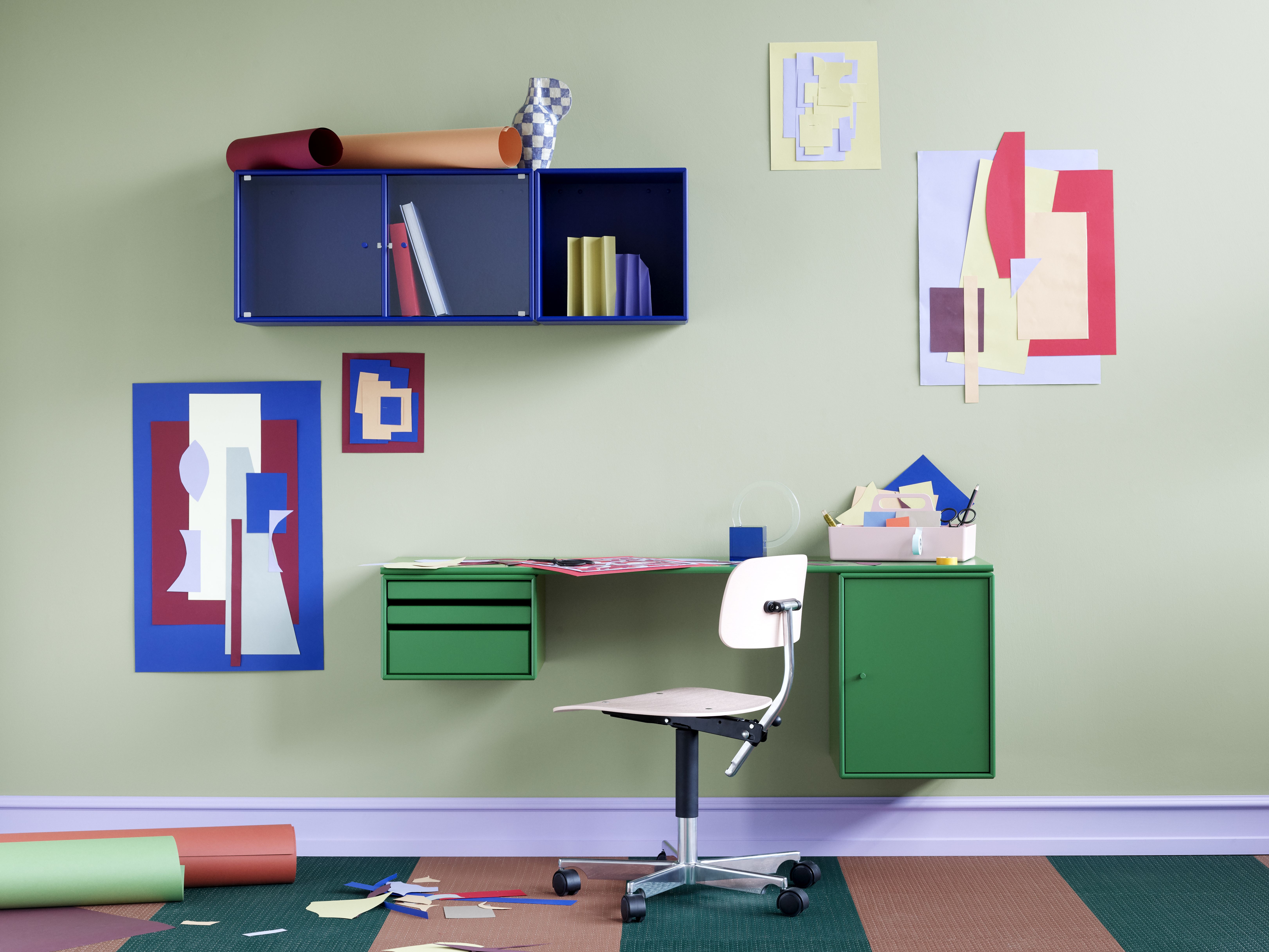 WORKSHOP Schreibtisch Montana QUICK SHIP in Grün mit Stuhl und blauen Regalen an grüner Wand.