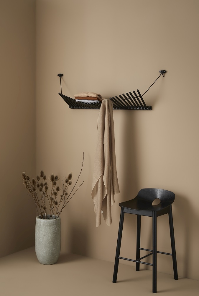 Knaegt Wandgarderobe von Woud in Schwarz: Moderne Garderobe aus Eiche mit Kleidung und Ablage.