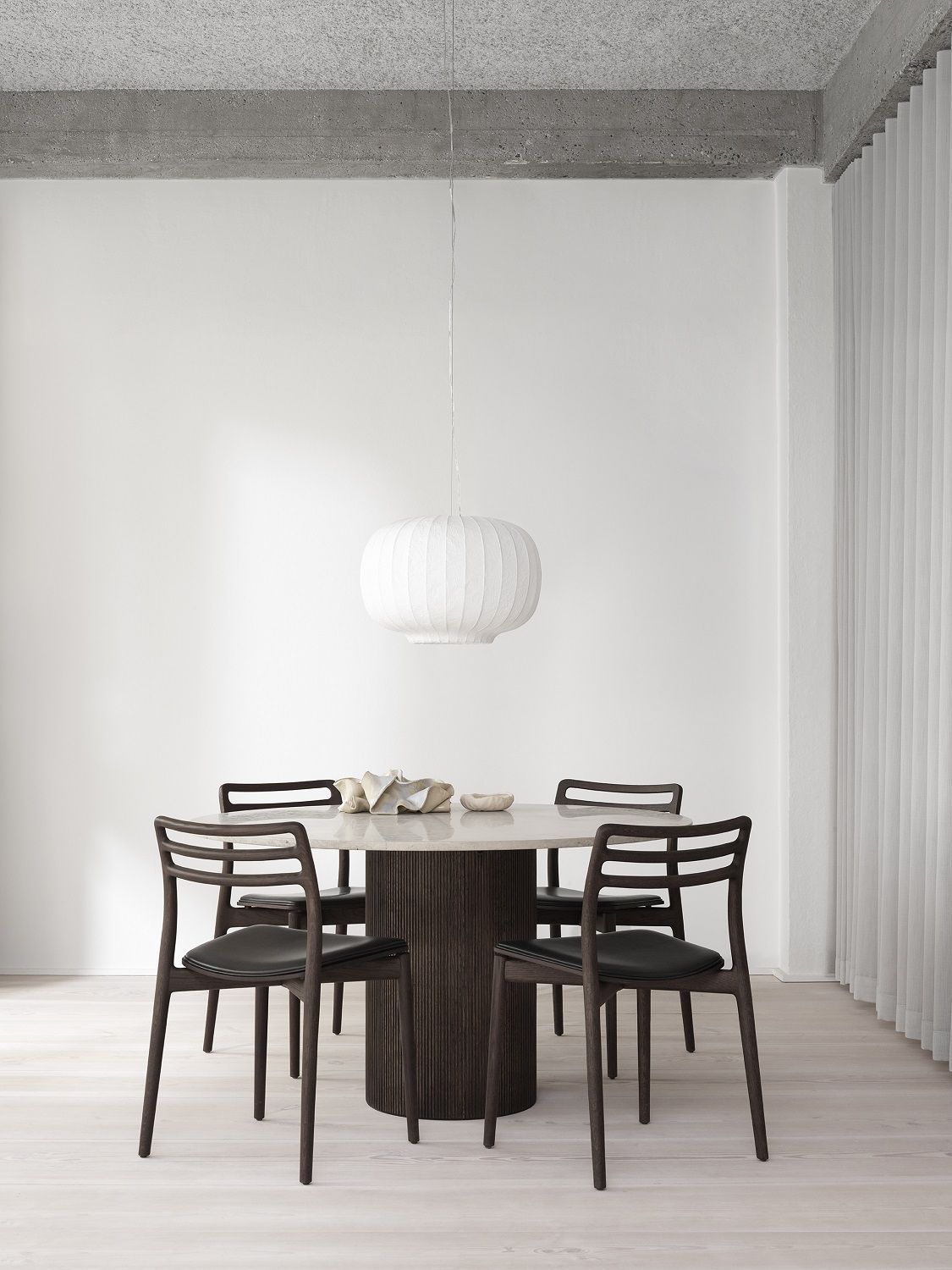 Vipp Cabin Tisch rund Eiche dunkel mit Stühlen und Lampe in minimalistischem Interieur.