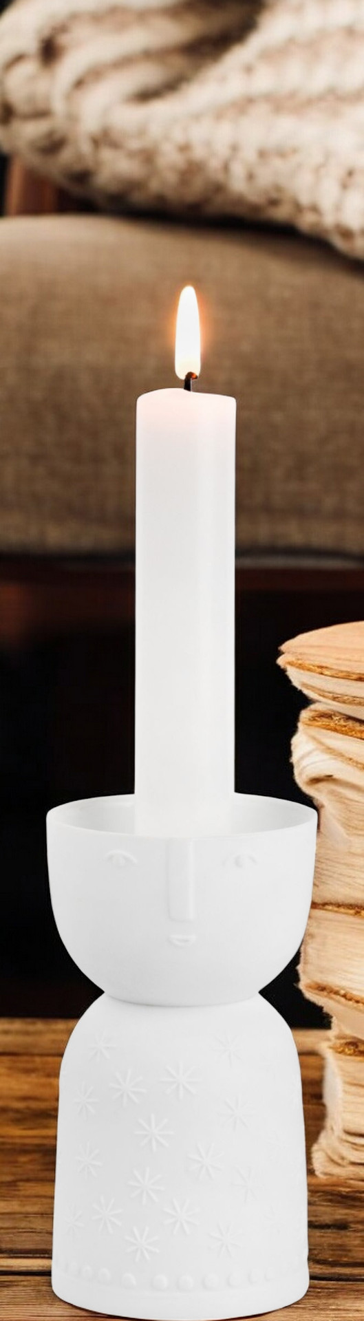 Kerzenhalter "Stella" von Räder mit brennender Kerze. Weißes Porzellan mit Gesicht und Sternen.