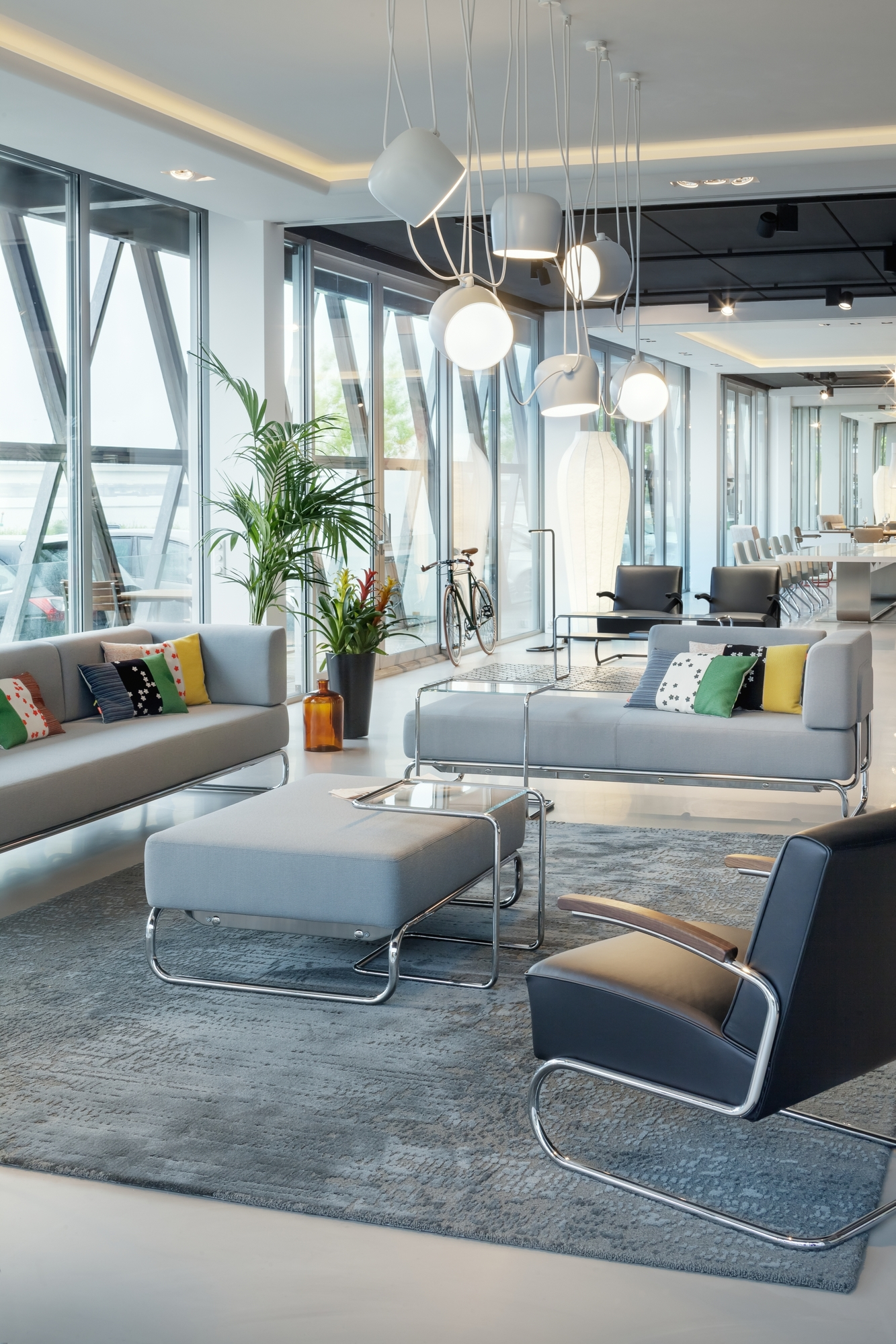 Helles Wohnzimmer mit grauem Thonet S 5003 Sofa, Sessel und Couchtisch mit Stahlrohrgestell.