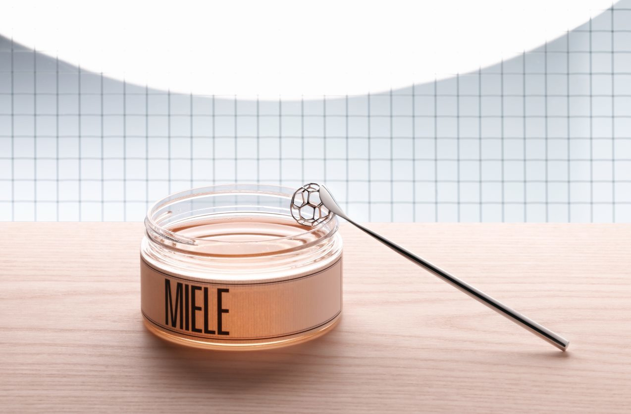 Alessi Honiglöffel MMI28 über Honigglas. Moderner Design Löffel für Honig, Akazienhonig.