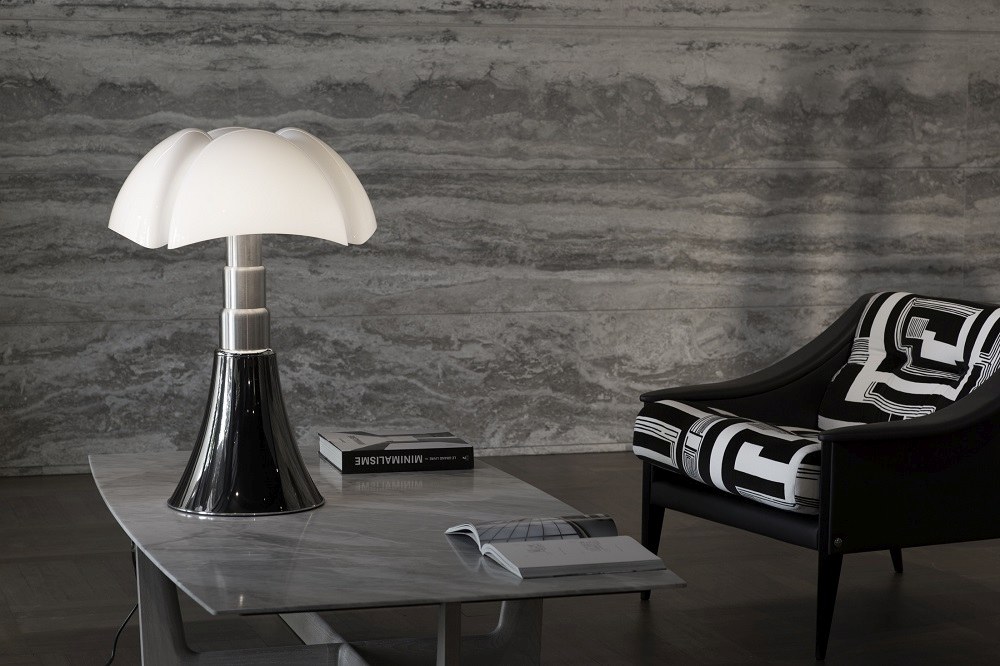 Pipistrello Tischleuchte von Martinelli Luce mit weißem Lampenschirm und schwarzem Fuß auf Tisch.
