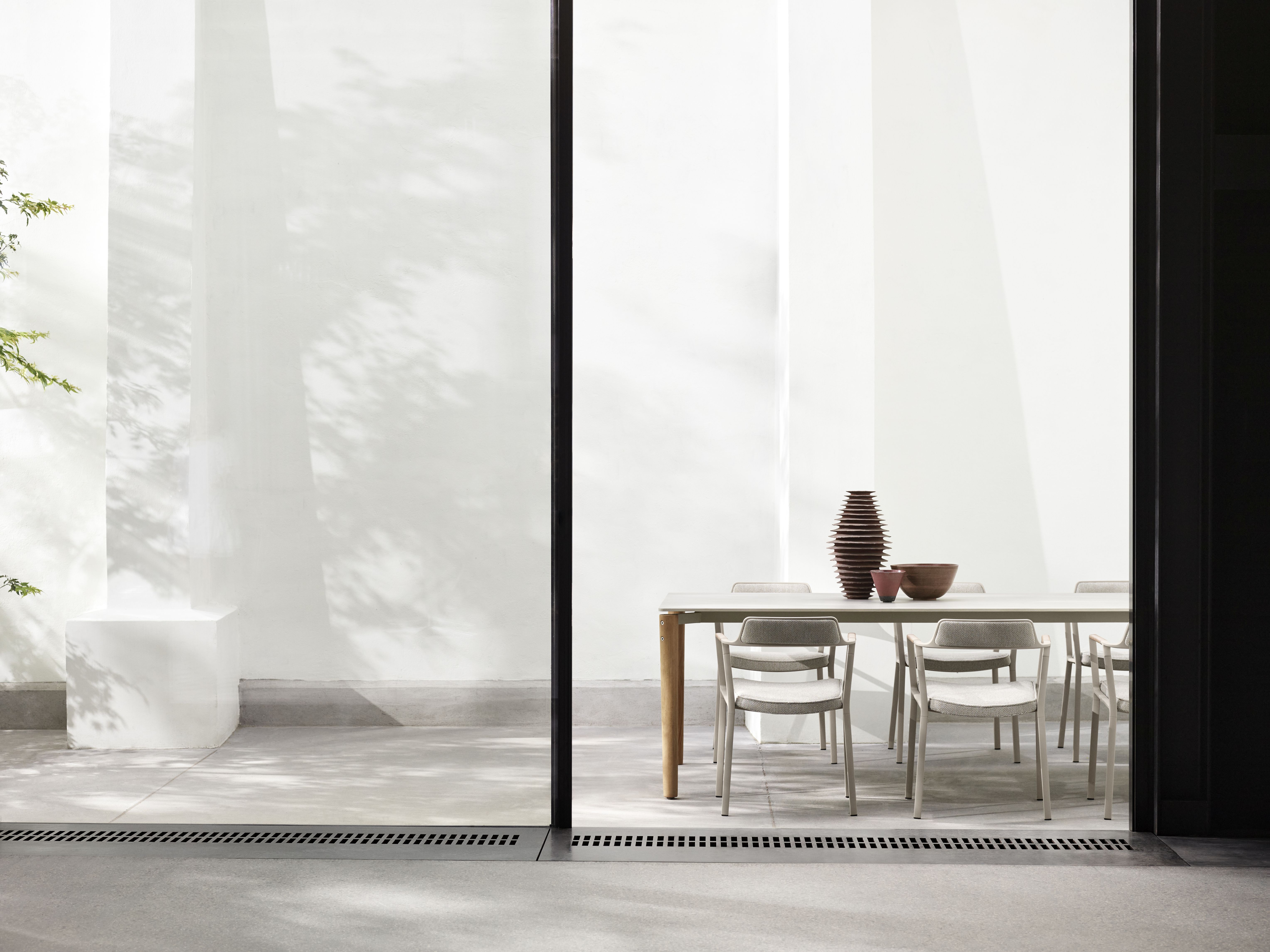 Vipp Open-Air Outdoor Stühle an Esstisch auf Terrasse. Moderne Gartenmöbel für stilvolles Wohnen im Freien.