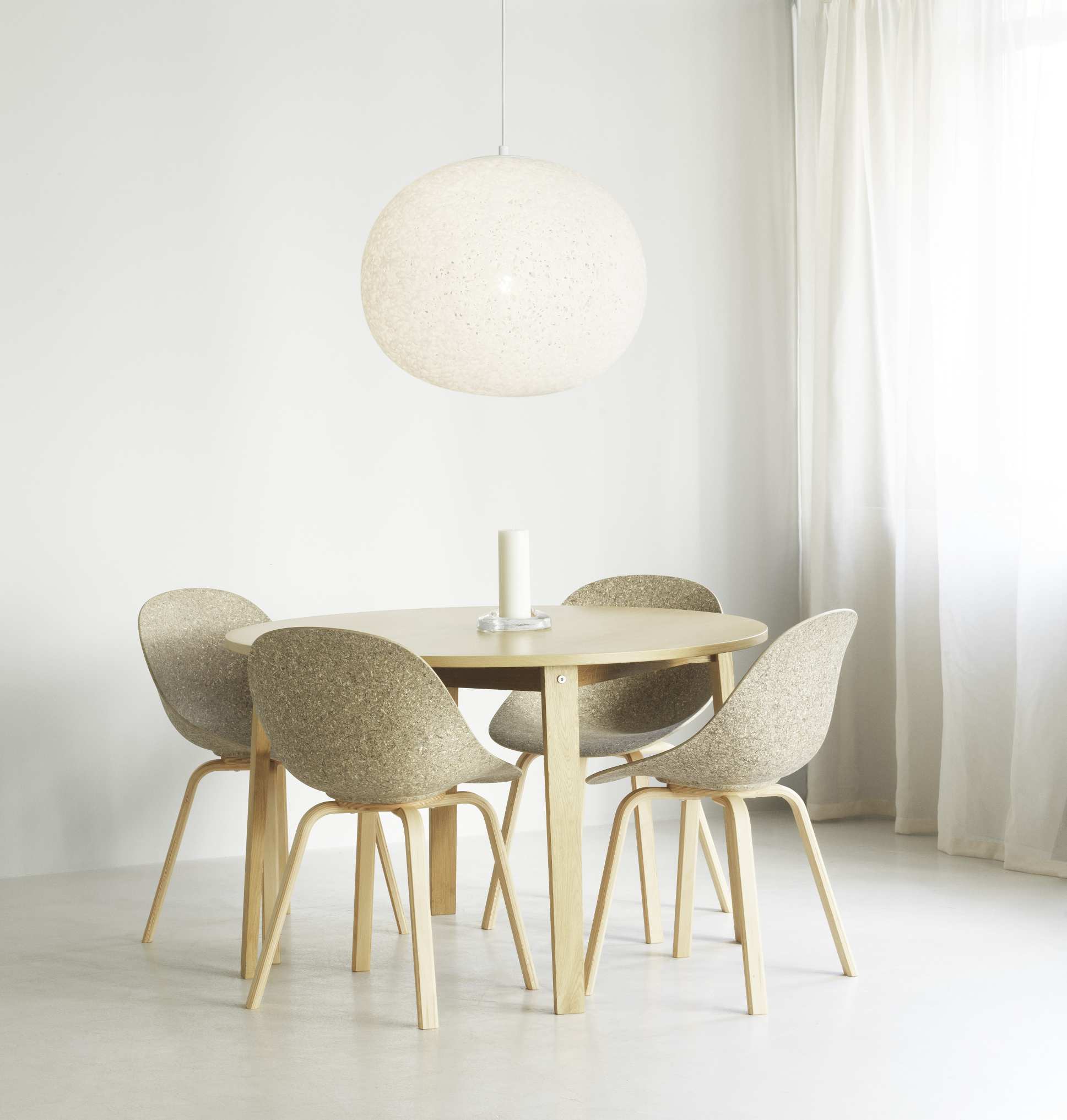 Esszimmer mit Normann Copenhagen Act Lamp Pendelleuchte und vier Stühlen um einen Tisch.