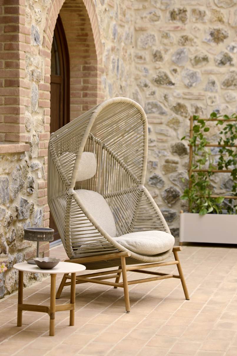 Beiger Cane-Line Hive Sessel für den Außenbereich mit Kissen und hohem Rückenteil.