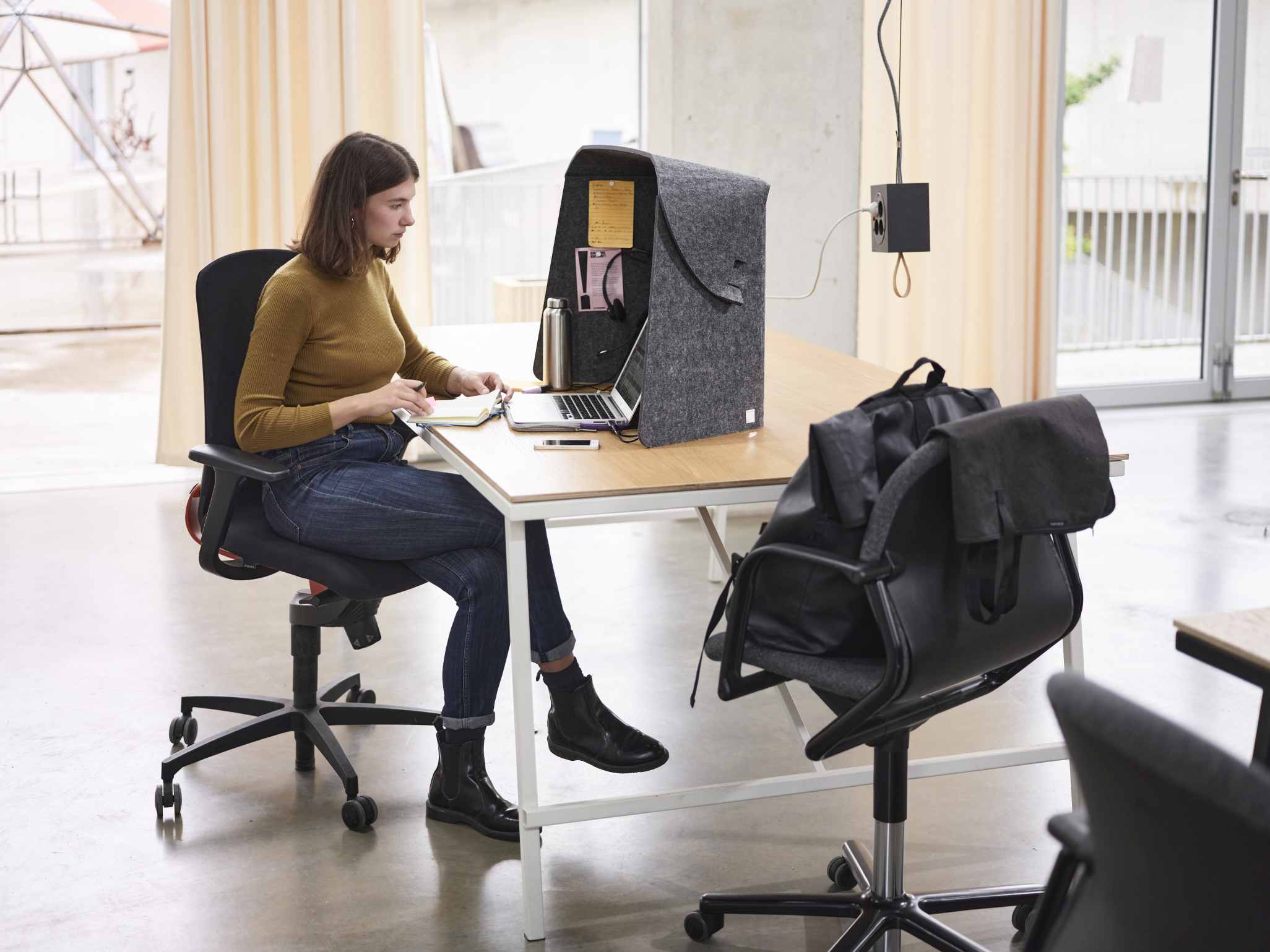 Frau arbeitet am Laptop im Wilkhahn Fold-Up-Workspace, einem mobilen, akustischen Arbeitsplatz.