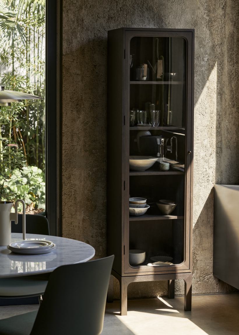 AndTradition Trace Vitrine SC87 aus dunklem Holz mit Glasfront, Geschirr und Dekoration im Innenraum.
