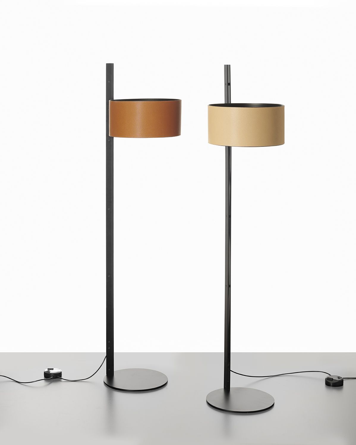 Zwei Oluce Stehleuchten Parallel 396 mit zylindrischen Lampenschirmen in Beige und Braun.