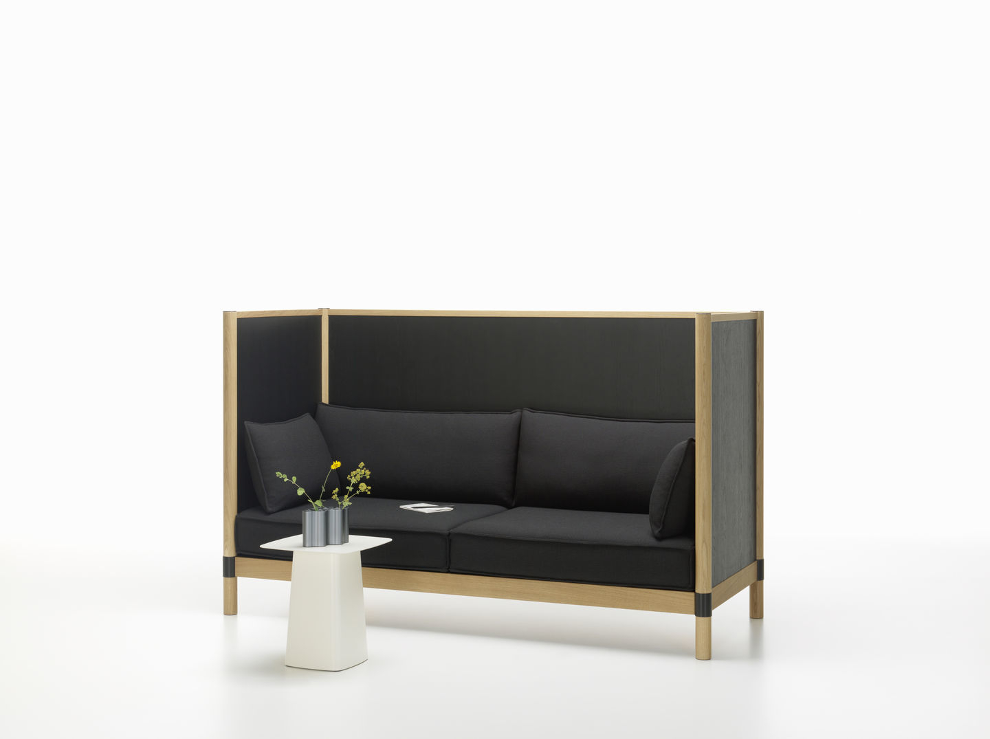 Weißer Metal Side Table Beistelltisch von Vitra neben einem schwarzen Sofa mit Holzrahmen.