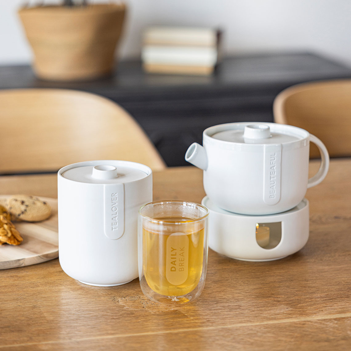 Cozy Time Stövchen und Teekanne klein von Räder, mit Teeglas und Gebäck.