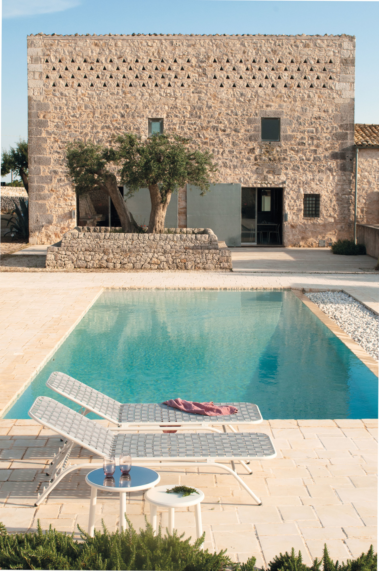 Emu Yard Beistelltisch in Weiß neben Pool und Liegestühlen, ideal für den Garten.