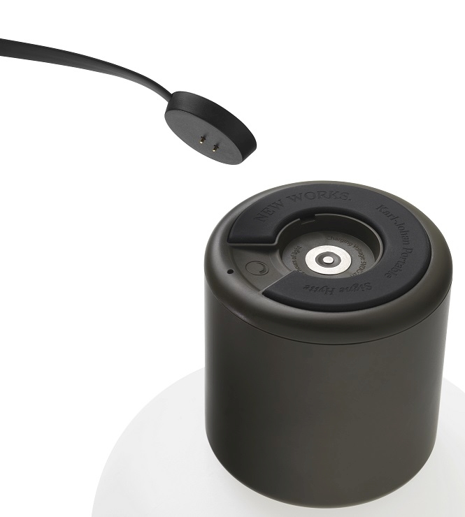 Detailaufnahme der Karl-Johan Akkuleuchte von New Works in Waldgrün mit Ladekabel.