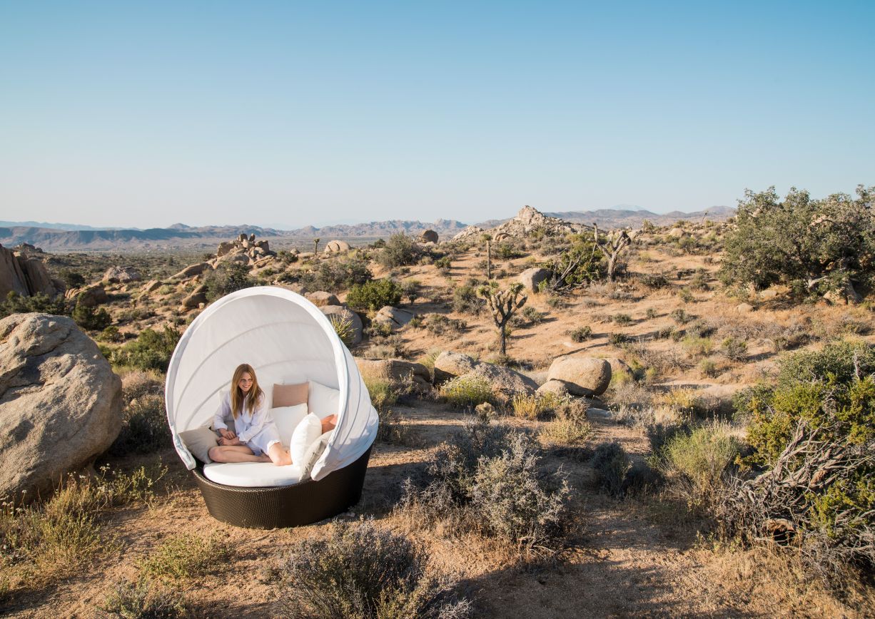 Frau entspannt auf der Dedon Orbit Sofainsel Vulcano mit Verdeck im Freien.