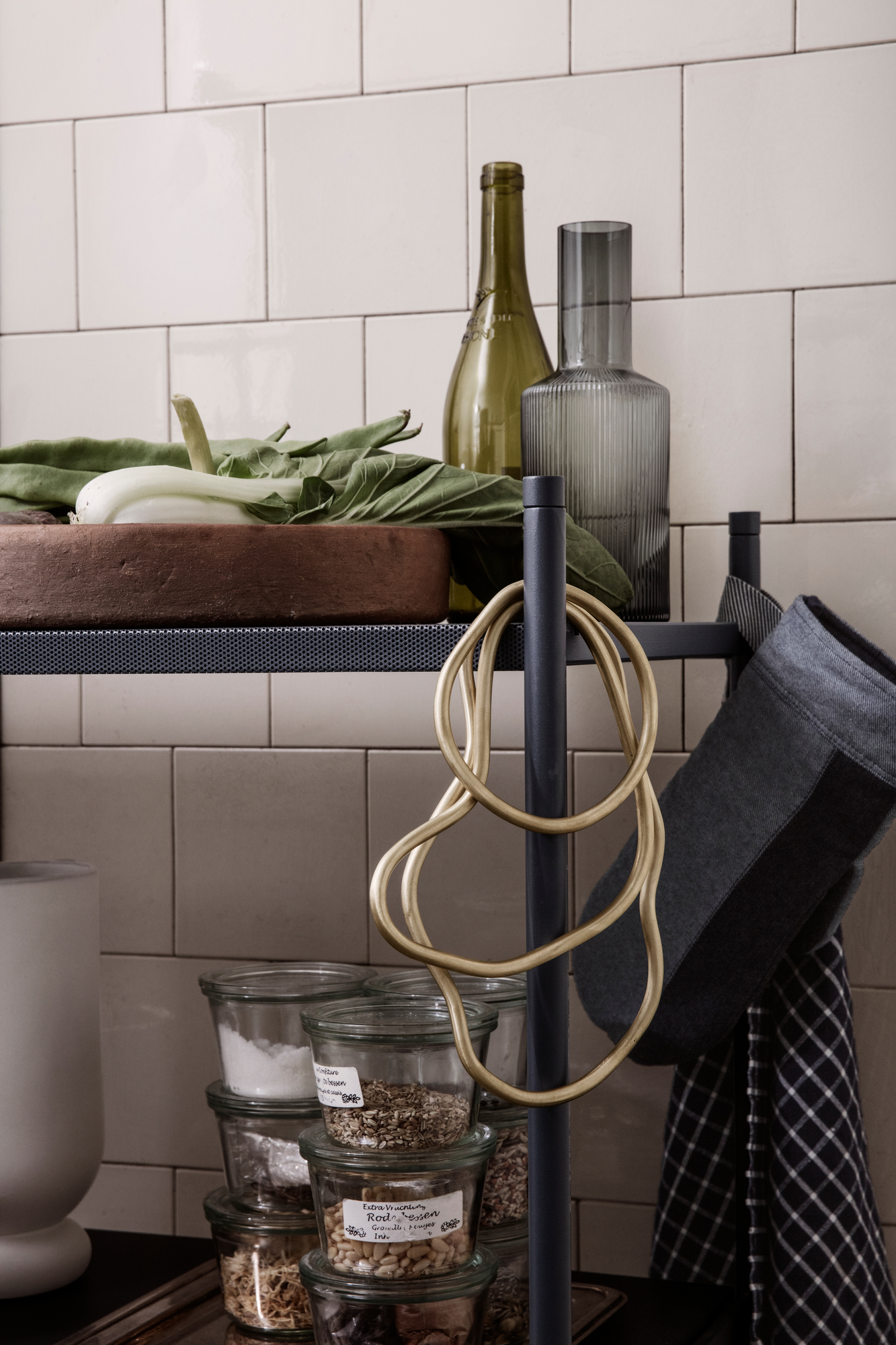 Detailaufnahme eines Küchenregals mit Ferm Living Karaffe in Rauchgrau und Vorratsgläsern.