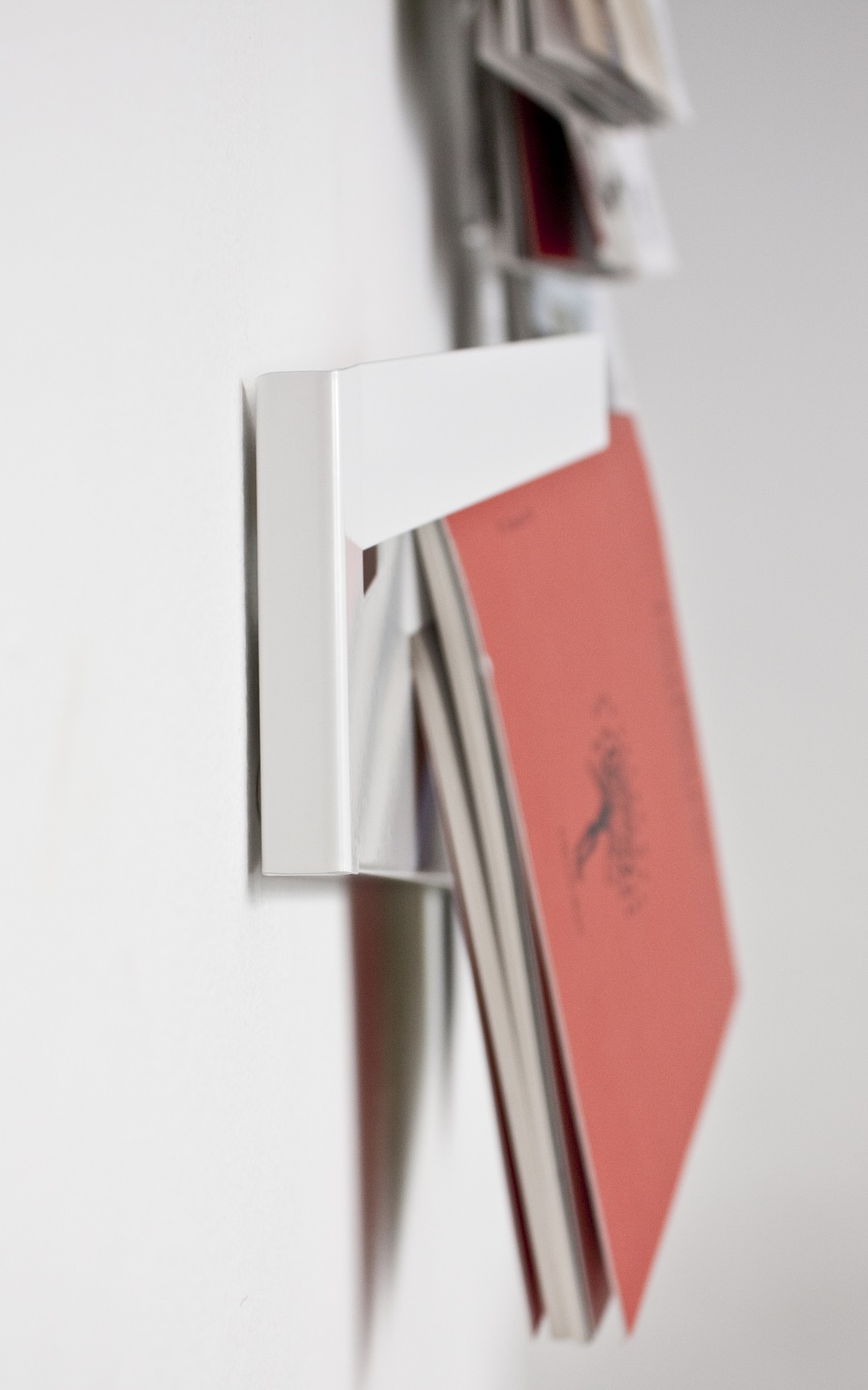 Weißer Mr_Magazinhalter von Müller Möbelwerkstätten an einer Wand mit Zeitschriften. Wandregal für Magazine.