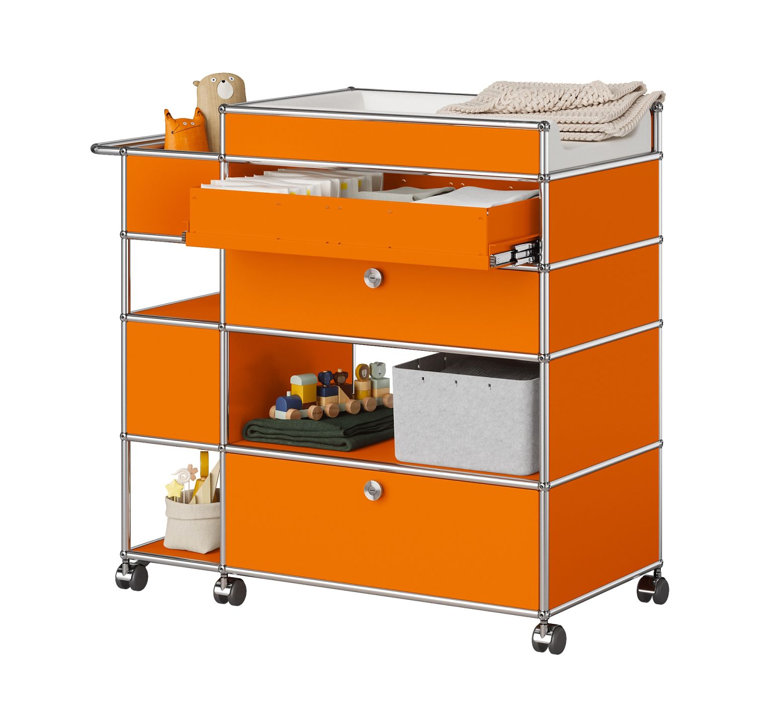 Orangefarbener USM Haller Wickeltisch mit Schubladen, Spielzeug und Stoffwindeln für Babyzimmer.