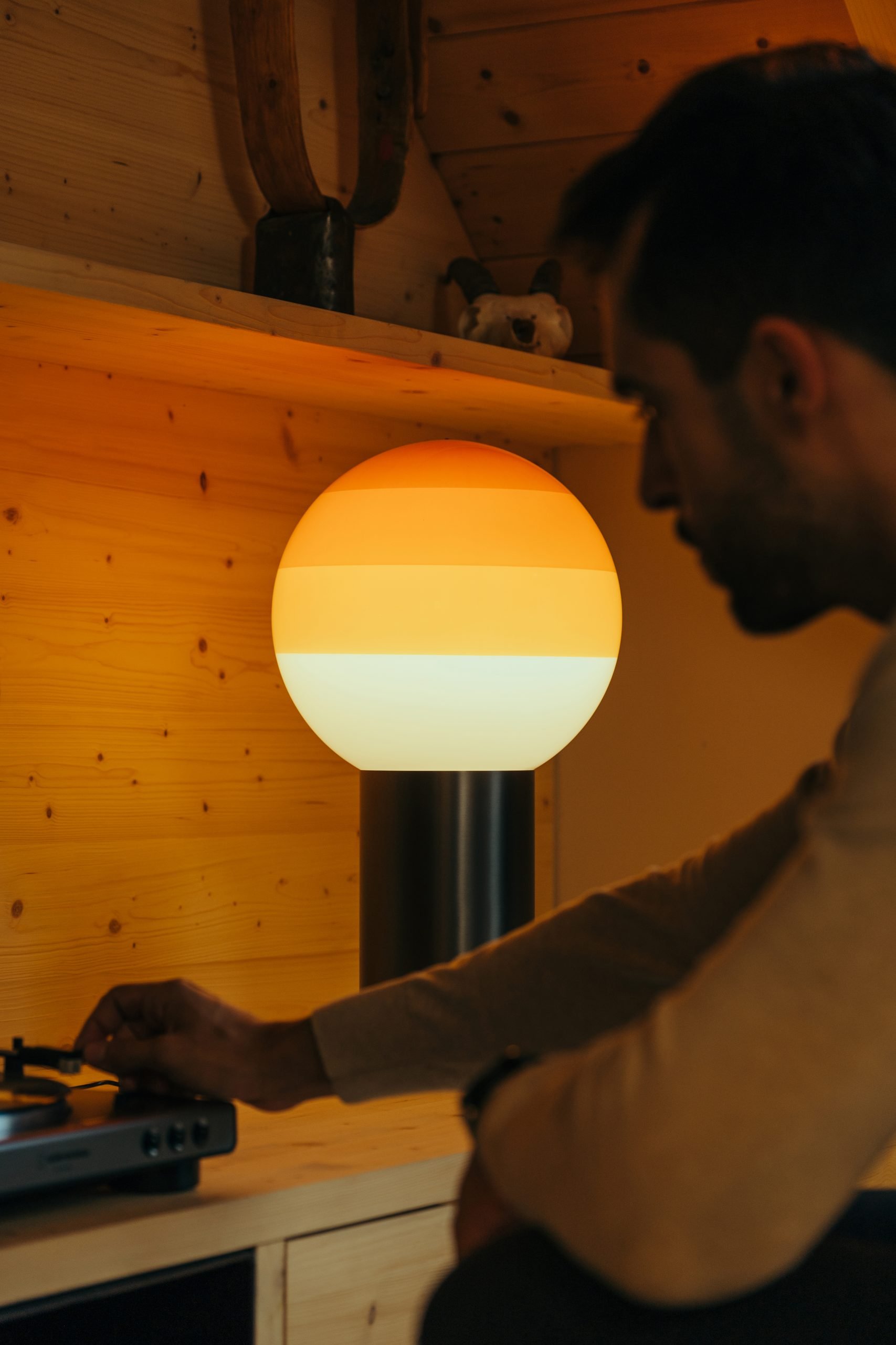 Marset Dipping Light M LED Tischleuchte mit warmem, gestreiftem Licht und schwarzem Fuß.