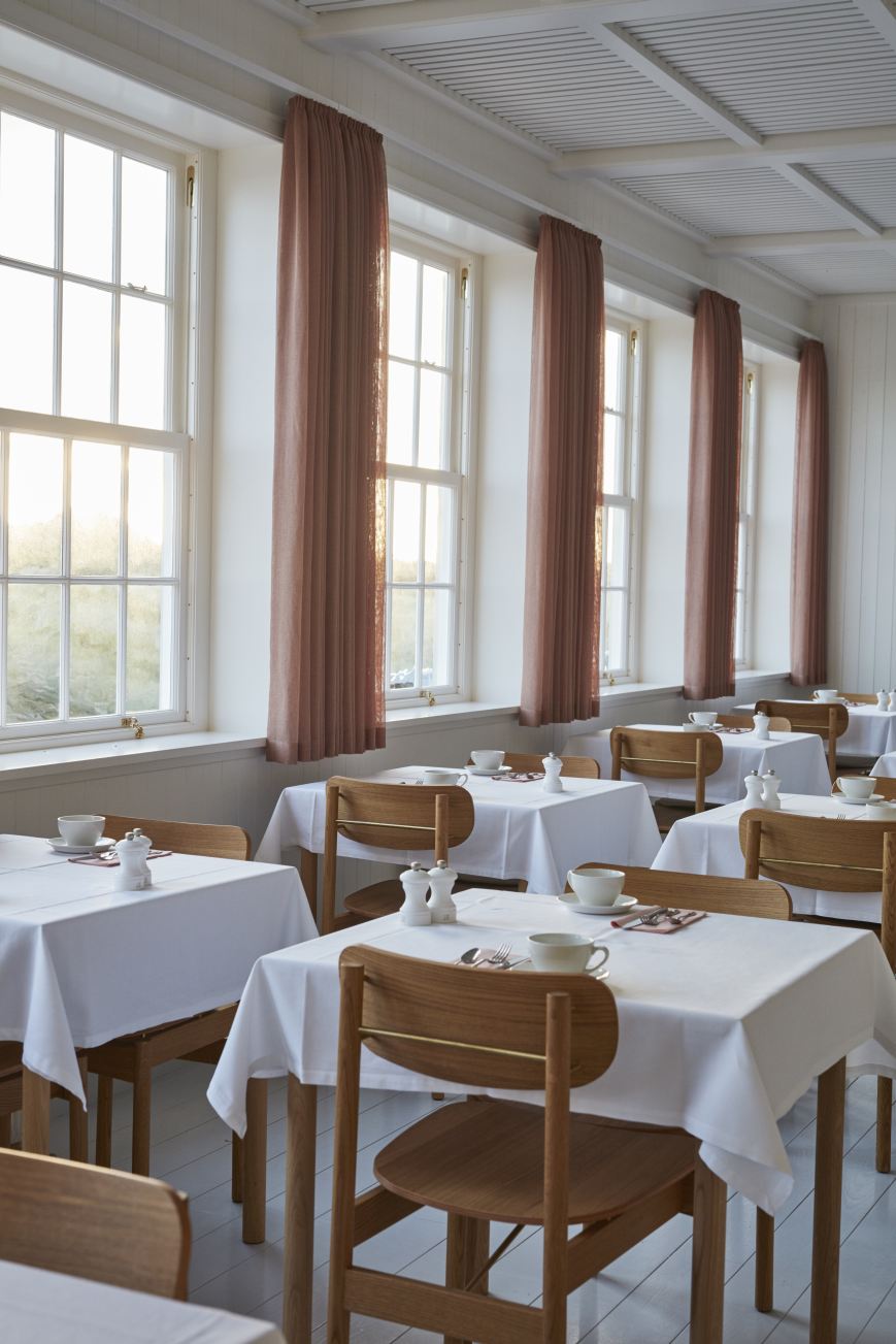 Helle Gaststube mit gedeckten Tischen und Vester Chair Stühlen von Skagerak by Fritz Hansen.