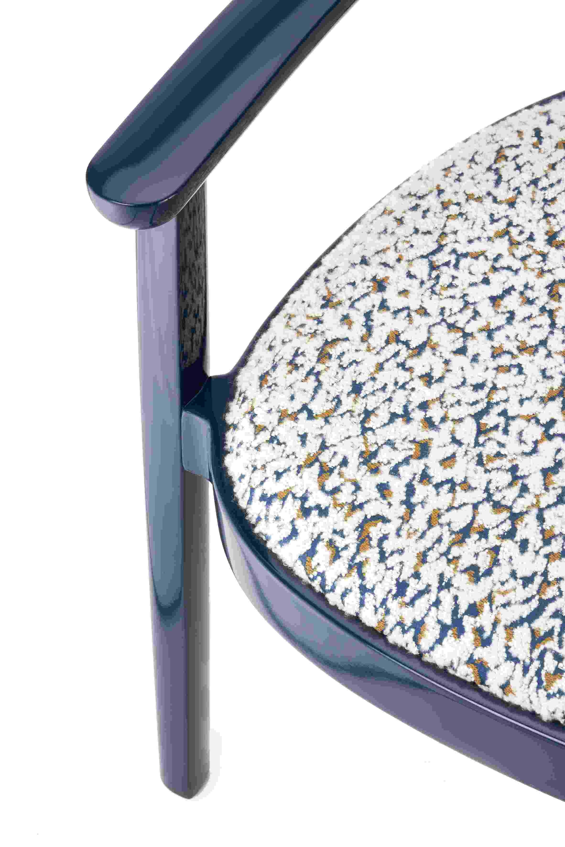 Detailaufnahme: Blauer Holzsesessel mit Armlehnen und gemustertem, gepolstertem Sitz. Thonet-Design.
